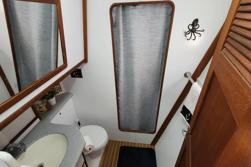 Slide: The Image of Bathroom interior of 2005 Endeavour 44 TrawlerCat with sink, toilet, and nautical decor. - 26