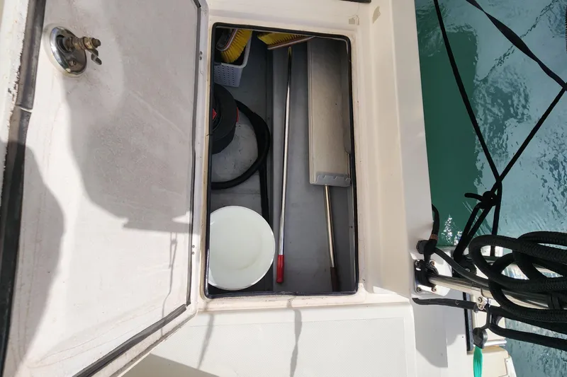 Slide: The Image of Open storage compartment on 2005 Endeavour 44 TrawlerCat, containing cleaning supplies and tools. - 55