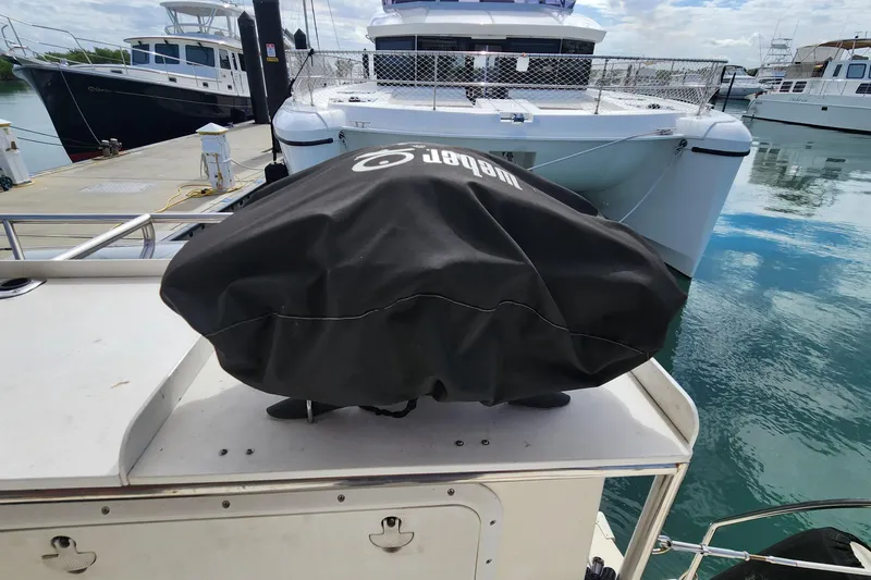 Slide: The Image of 2005 Endeavour 44 TrawlerCat docked, featuring covered equipment on deck. - 57