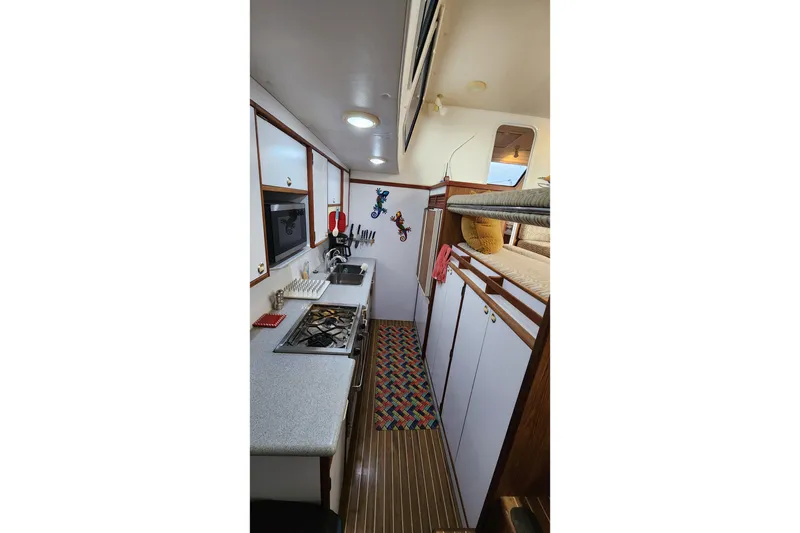 Slide: The Image of 2005 Endeavour 44 TrawlerCat galley with stove, sink, and colorful decor. - 6