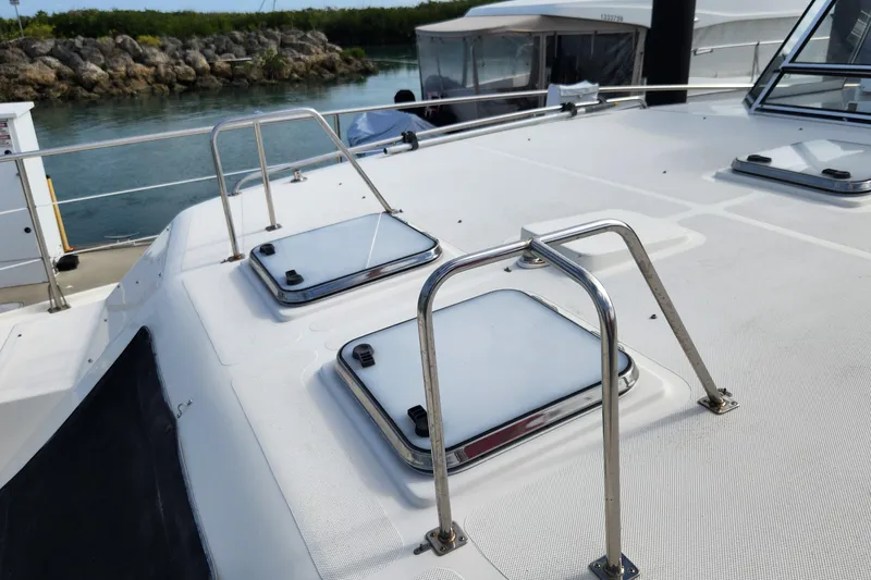 Slide: The Image of 2005 Endeavour 44 TrawlerCat deck with hatches and railing, docked by water. - 62