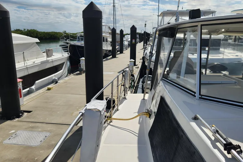 Slide: The Image of 2005 Endeavour 44 TrawlerCat docked at marina under cloudy sky. - 70