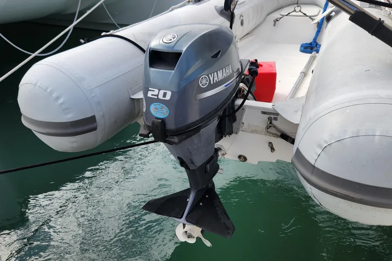 Slide: The Image of Inflatable boat with Yamaha 20 outboard motor, docked on water. - 74