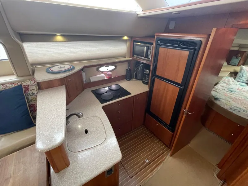 Slide: The Image of 2004 Meridian 459 Motoryacht kitchen with stove, sink, and refrigerator. - 31