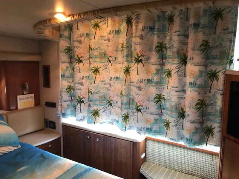Slide: The Image of 2004 Meridian 459 Motoryacht interior with tropical-themed curtains and cozy cabin decor. - 35