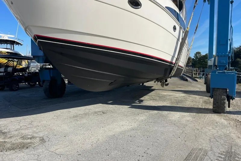 Slide: The Image of 2004 Meridian 459 Motoryacht being lifted by a blue crane at a marina. - 56