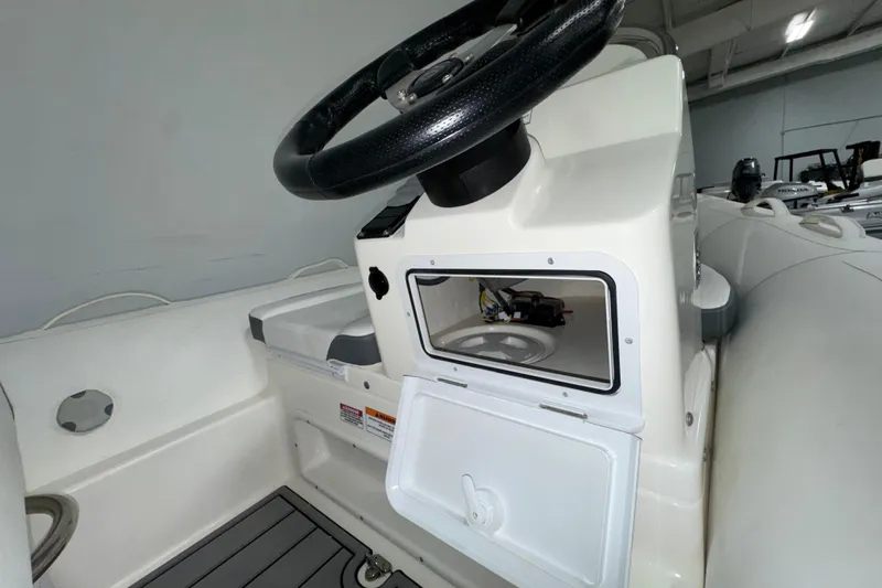 Slide: The Image of 2026 Zodiac Yachtline 400 boat console with steering wheel and storage compartment. - 7