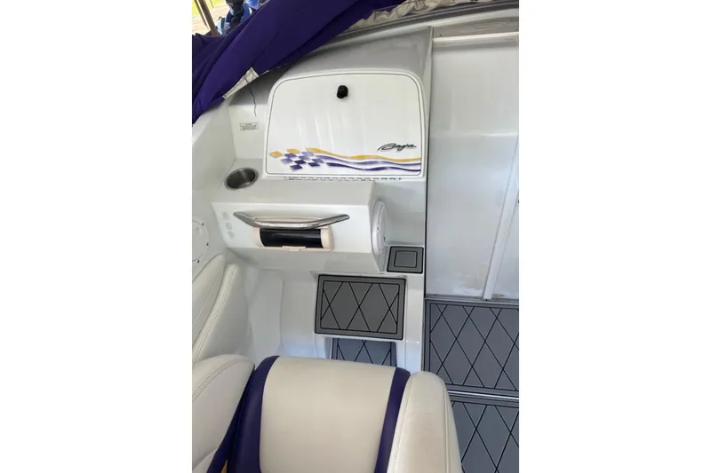 Slide: The Image of Interior of a 1999 Baja 33 Outlaw boat with white and purple seating. - 10
