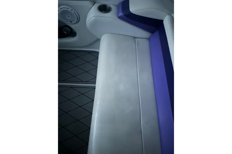 Slide: The Image of 1999 Baja 33 Outlaw interior with white and purple seating, cup holder, and speaker. - 14