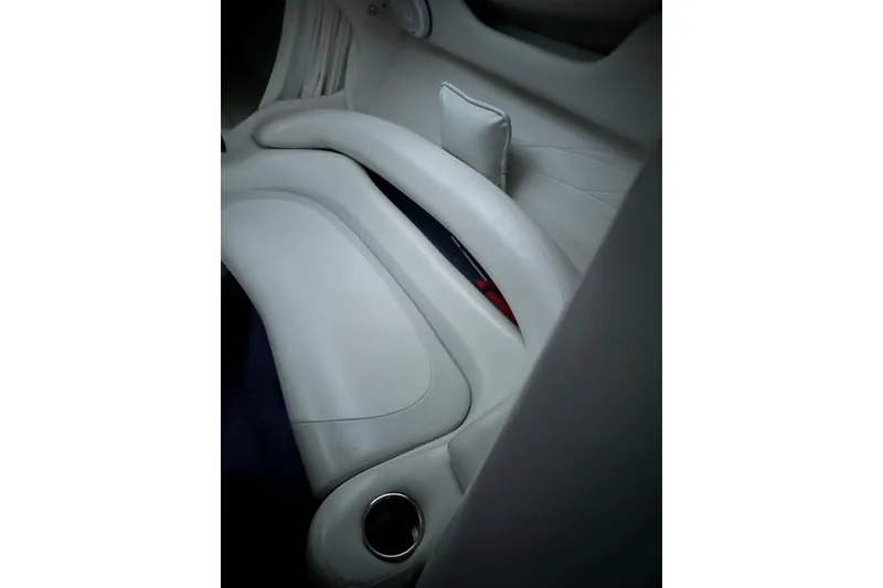Slide: The Image of Interior of a 1999 Baja 33 Outlaw boat, featuring sleek white seating. - 15