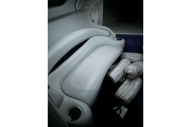 Slide: The Image of Interior of a 1999 Baja 33 Outlaw boat with white seating and cup holders. - 16