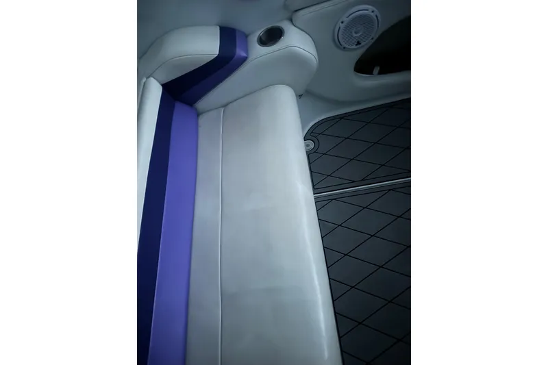 Slide: The Image of 1999 Baja 33 Outlaw interior with white and purple seating, speaker, and cup holder. - 17