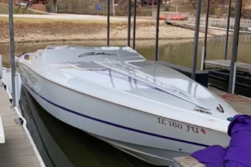 Slide: The Image of 1999 Baja 33 Outlaw speedboat docked in a marina. - 4