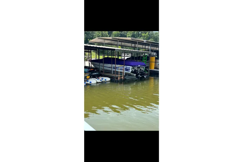 Slide: The Image of 1999 Baja 33 Outlaw boat docked under a covered marina. - 8