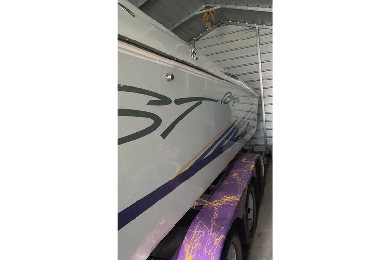 Slide: The Image of 1999 Baja 33 Outlaw boat in storage, featuring sleek design and vibrant trailer. - 9