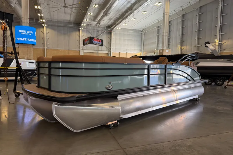 The Image of 2026 Harris Cruiser 230 pontoon boat displayed indoors at a state fair. - 0
