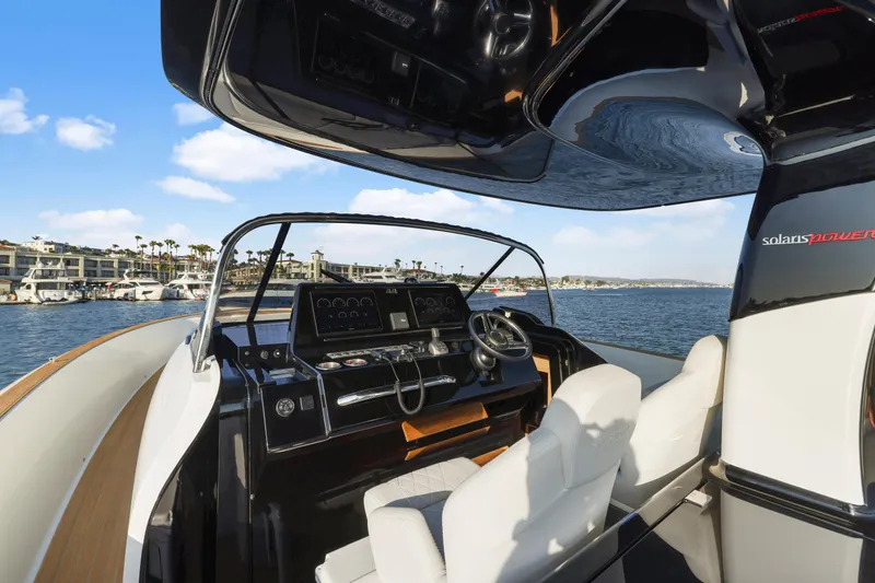 Slide: The Image of 2022 Solaris Power yacht interior, featuring modern helm and luxurious seating on open water. - 12