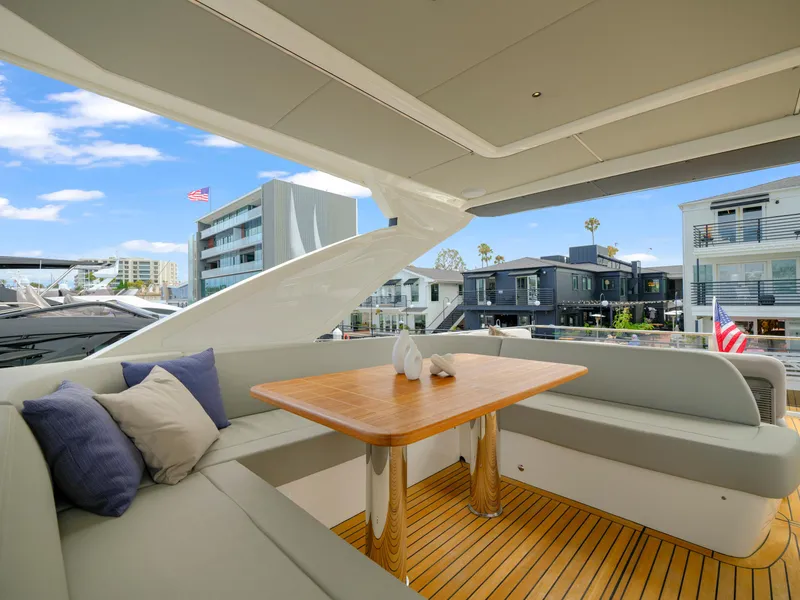 Slide: The Image of Luxurious 2024 Absolute 60 Fly yacht deck with elegant seating and wooden table. - 12