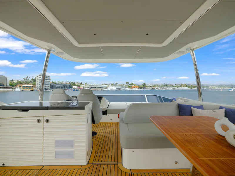 Slide: The Image of Luxurious 2024 Absolute 60 Fly yacht interior with waterfront view, featuring elegant seating and dining area. - 13