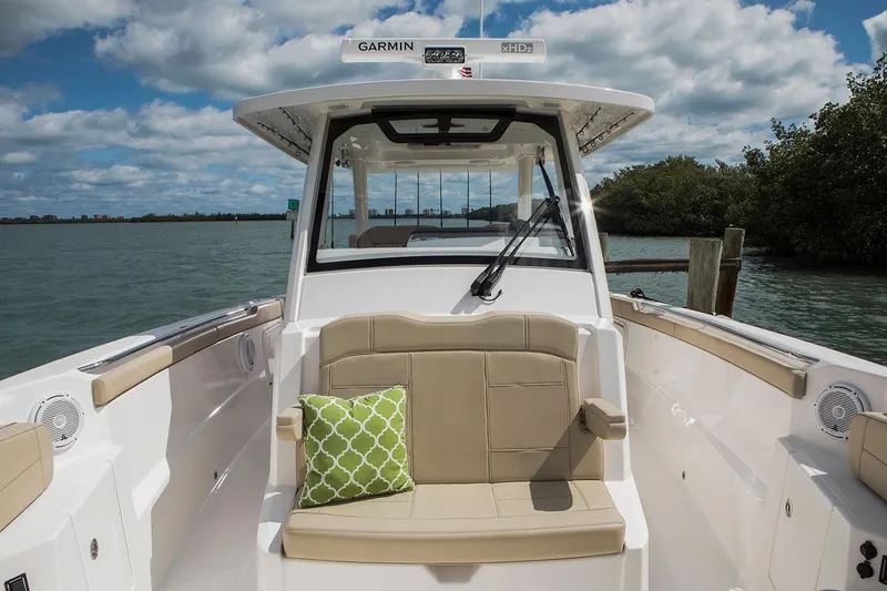 Slide: The Image of Manufacturer Provided Image: 2021 Pursuit S 328 Sport boat interior with beige seating and green pillow. - 10