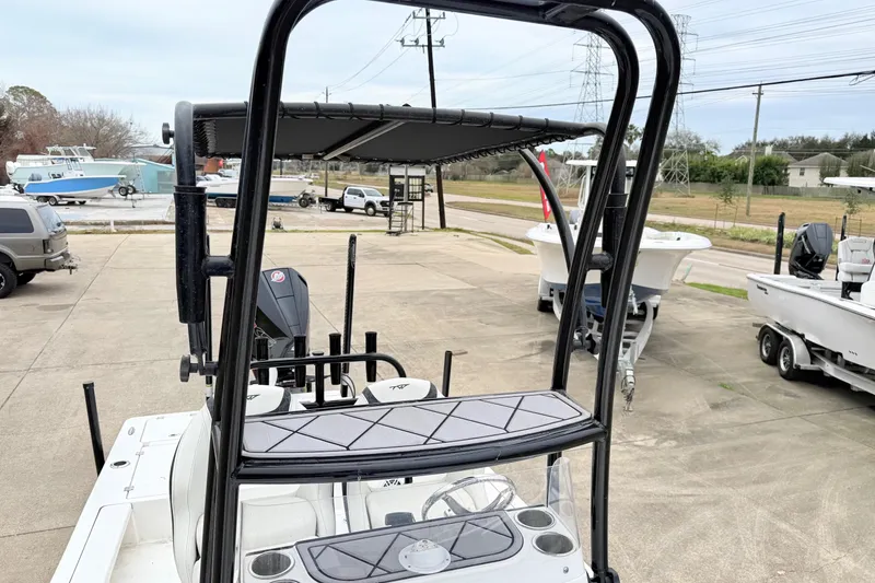 Slide: The Image of 2023 Tidewater 25 TPC Raptor boat with T-top and console, parked outdoors. - 12