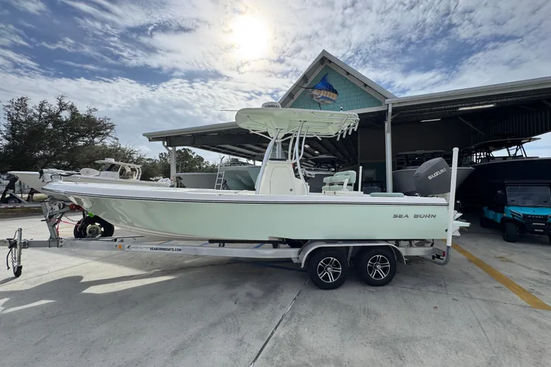 The Image of 2017 Sea Born FX25 Bay boat on trailer, parked outside a marina under a cloudy sky. - 1