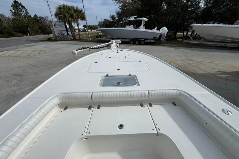 Slide: The Image of 2017 Sea Born FX25 Bay boat, white deck, parked outdoors near palm trees. - 18