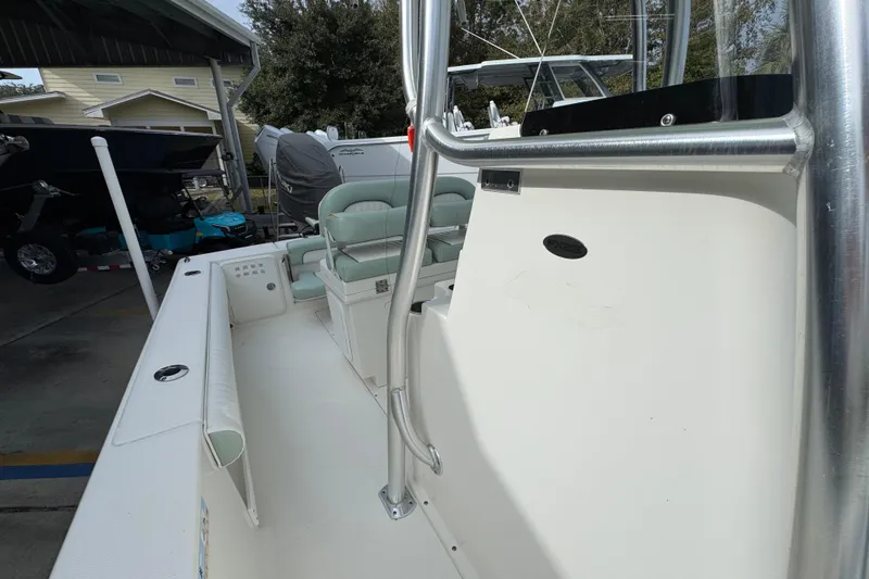 Slide: The Image of 2017 Sea Born FX25 Bay boat interior with seating and console, parked in a covered area. - 26