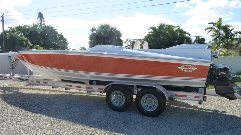 The Image of 1971 Magnum Sport boat on a trailer in a sunny outdoor setting. - 0