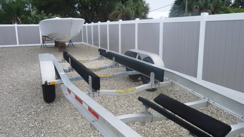 Slide: The Image of 1971 Magnum Sport boat trailer in a gravel yard with a white fence. - 18