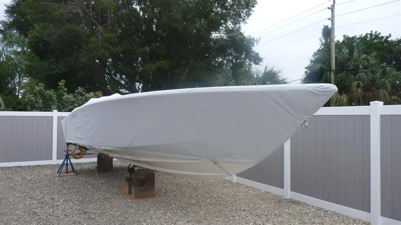 Slide: The Image of 1971 Magnum Sport boat covered and stored on blocks in a fenced yard. - 20