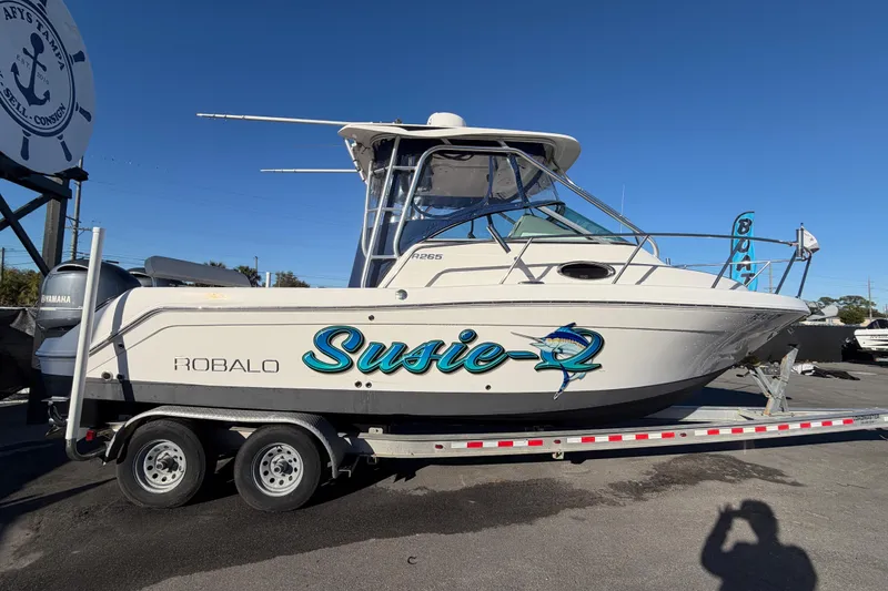 Slide: The Image of 2017 Robalo R265 Walkaround boat on trailer, named "Susie-Q," with Yamaha engines. - 1