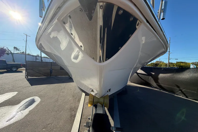 Slide: The Image of 2017 Robalo R265 Walkaround boat on trailer, viewed from the front under bright sunlight. - 13