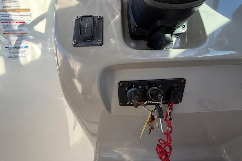 Slide: The Image of Control panel of a 2017 Robalo R265 Walkaround boat with keys and switches. - 31