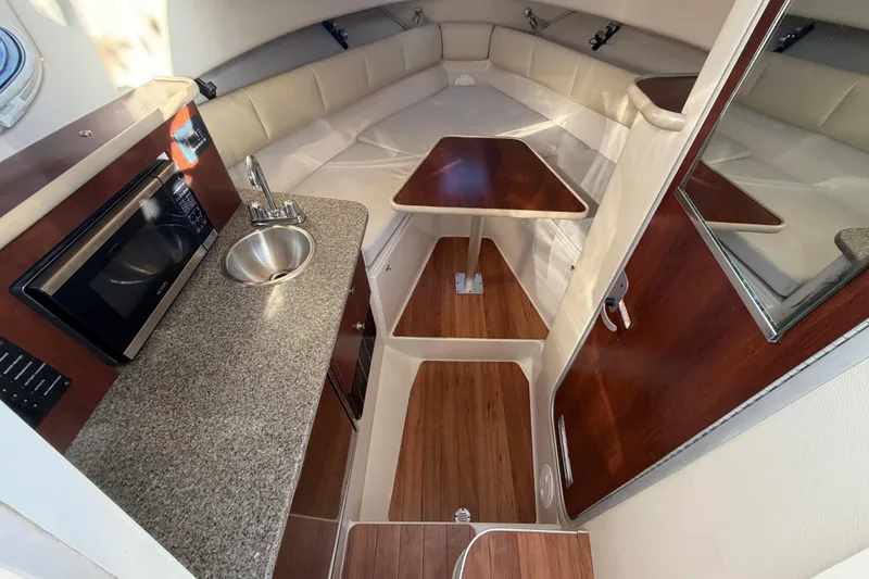 Slide: The Image of 2017 Robalo R265 Walkaround cabin interior with kitchenette, sink, and seating area. - 39