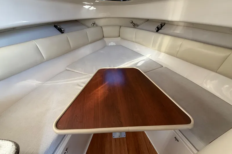 Slide: The Image of 2017 Robalo R265 Walkaround cabin interior with cushioned seating and wooden table. - 41