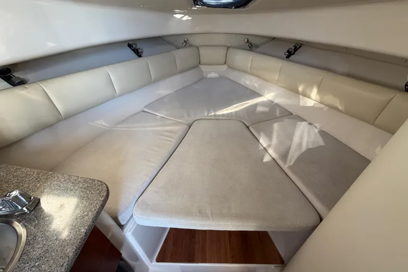 Slide: The Image of 2017 Robalo R265 Walkaround cabin interior with cushioned seating and compact kitchenette. - 42