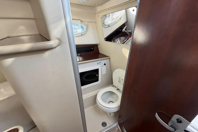 Slide: The Image of 2017 Robalo R265 Walkaround boat interior with compact bathroom and sink. - 44