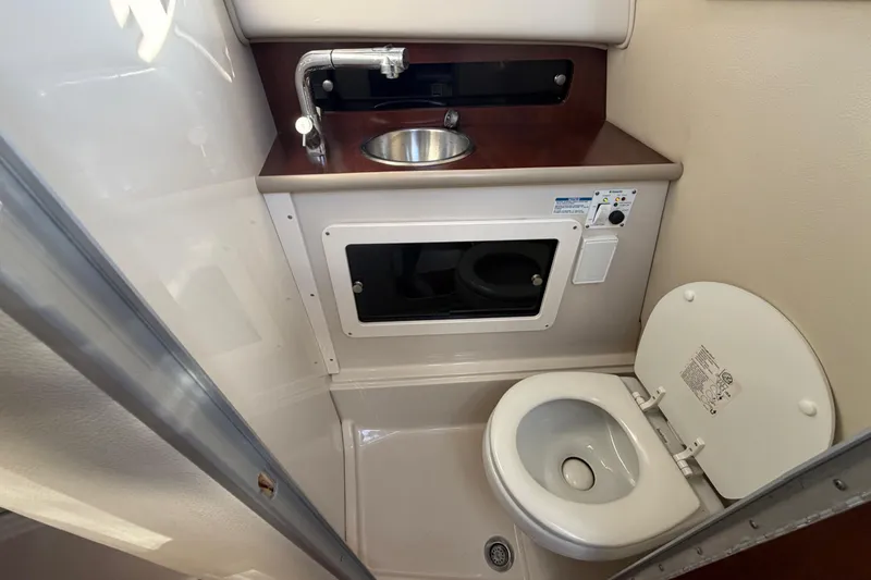 Slide: The Image of 2017 Robalo R265 Walkaround boat bathroom with sink and toilet. - 45