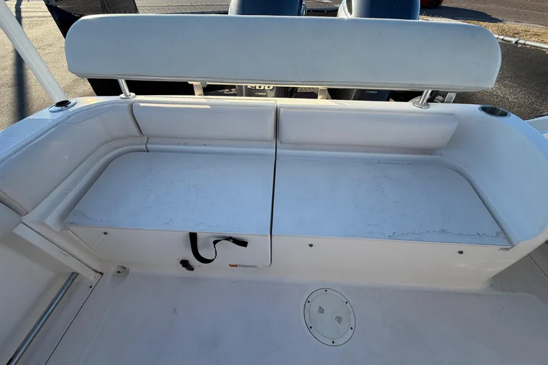 Slide: The Image of 2017 Robalo R265 Walkaround boat seating area with white cushioned bench. - 61