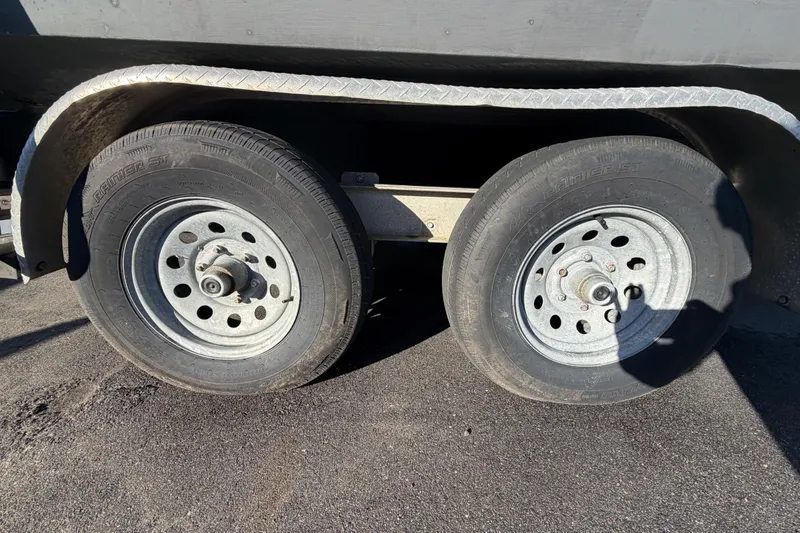 Slide: The Image of Trailer wheels of a 2017 Robalo R265 Walkaround boat on asphalt. - 67