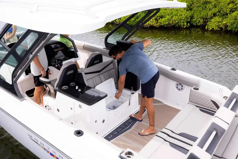 Slide: The Image of Men on a 2026 Monterey Elite 30 OB boat by the water. - 28