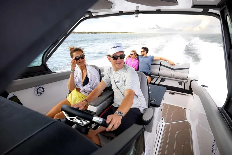Slide: The Image of Monterey Elite 30 OB 2026 on water with happy passengers. - 47
