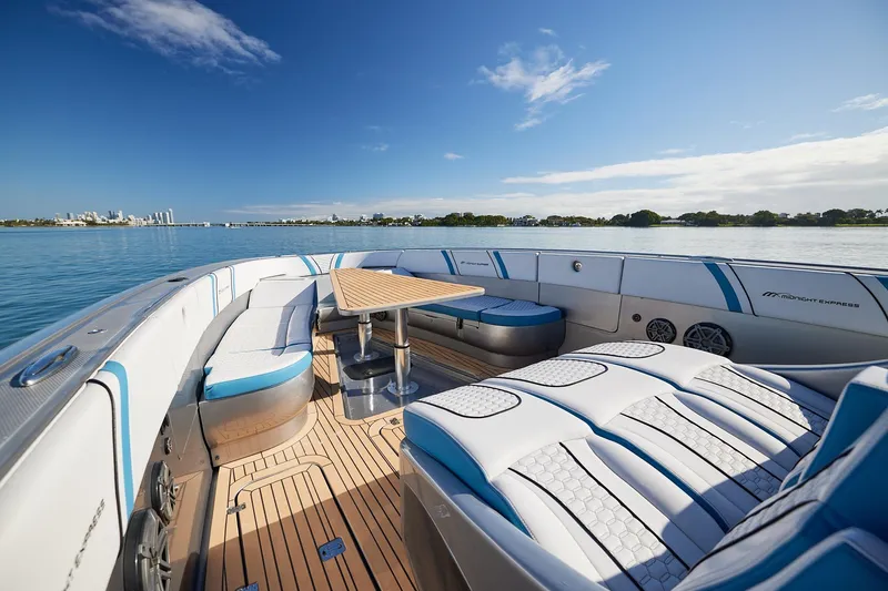 Slide: The Image of Luxurious Midnight Express 43' Open boat interior with seating and table on calm water. - 13