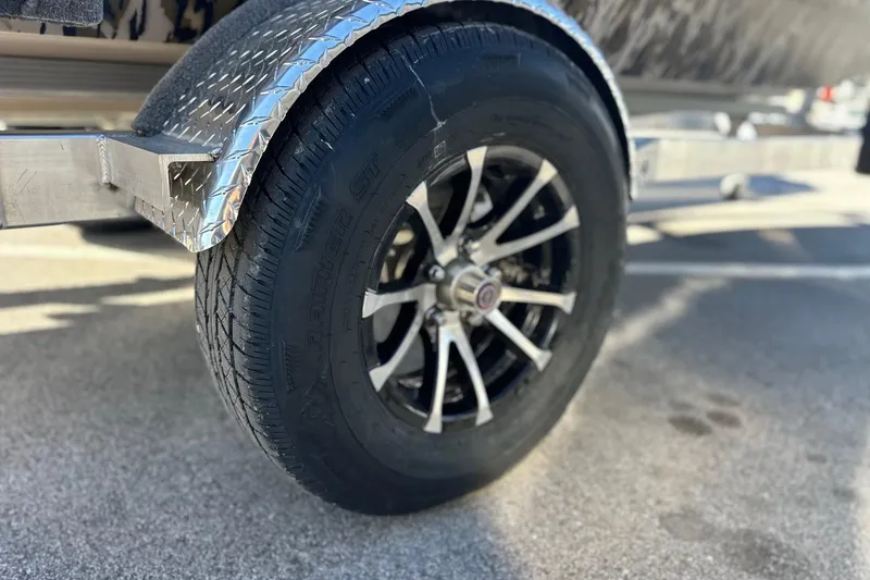 Slide: The Image of Close-up of a 2026 Avid 16 Commander trailer wheel with metallic fender. - 13