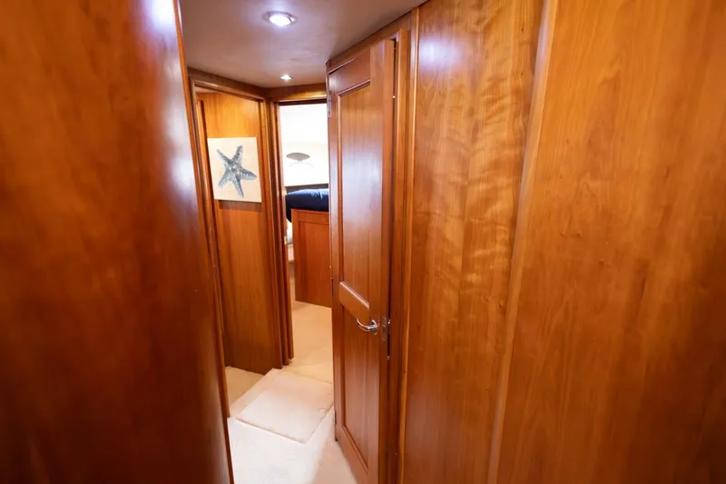 Slide: The Image of Interior hallway of 2001 Silverton 410 Sport Bridge with wooden paneling and starfish artwork. - 16