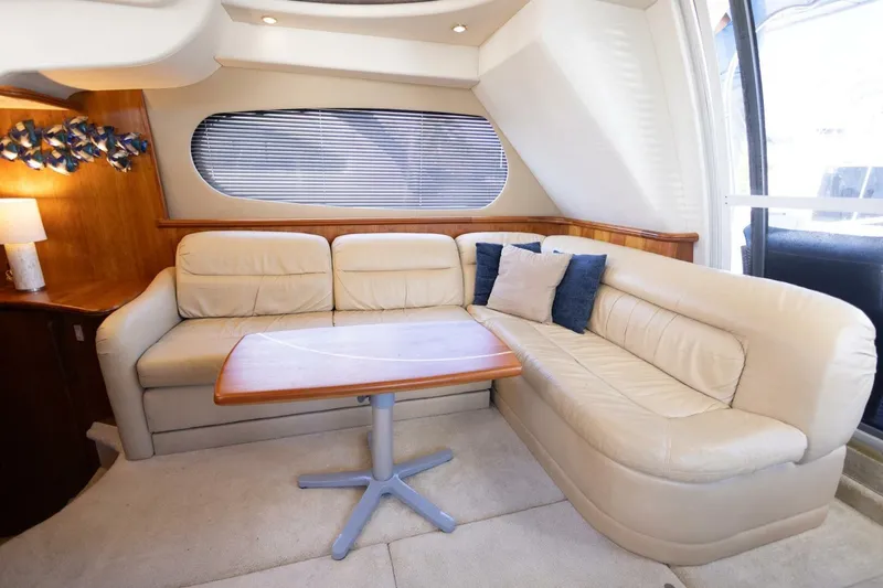 Slide: The Image of Luxurious interior of 2001 Silverton 410 Sport Bridge with cream leather seating and wooden table. - 21