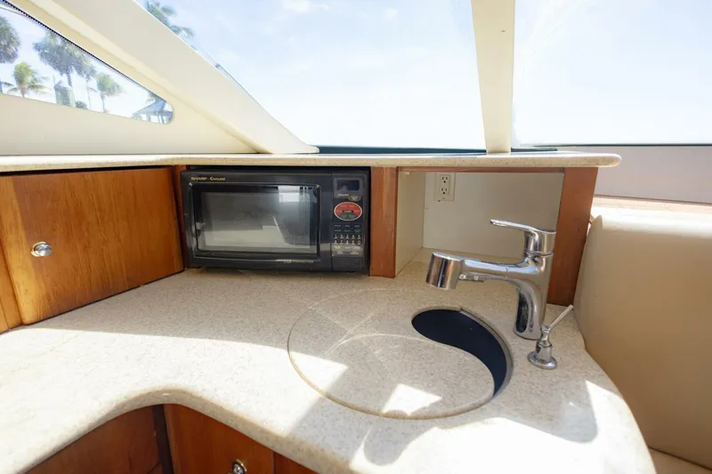 Slide: The Image of 2001 Silverton 410 Sport Bridge kitchen area with microwave and sink. - 28