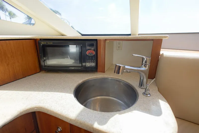 Slide: The Image of 2001 Silverton 410 Sport Bridge kitchen area with microwave and sink. - 29