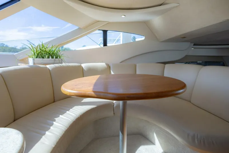 Slide: The Image of Luxurious interior of 2001 Silverton 410 Sport Bridge with curved seating and wooden table. - 32